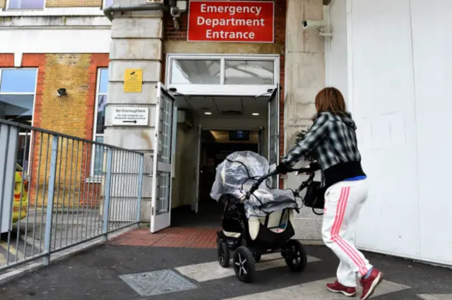 Женщина с ребенком направляется в отделение неотложной помощи в Лондоне