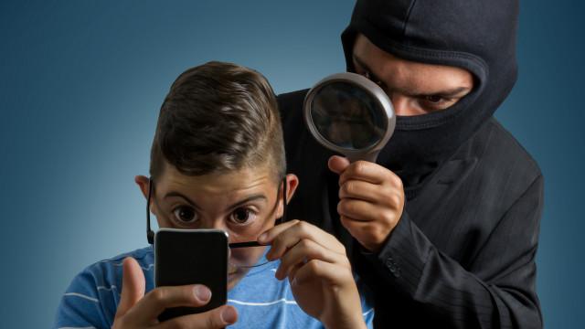 Hombre espiando a un niño mientras que mira su celular