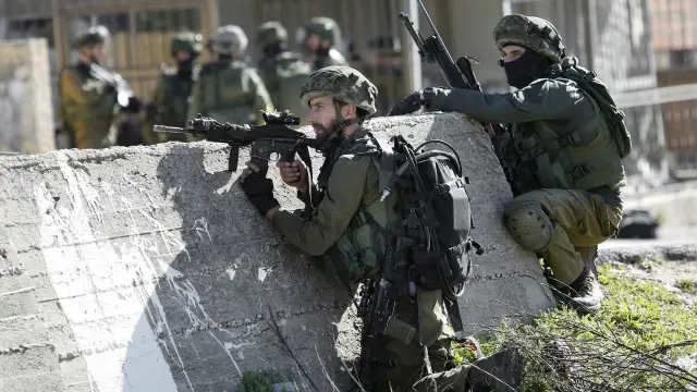 جنود الجيش الإسرائيلي يستعدون لاقتحام مخيم لاجئين فلسطينيين قرب رام الله. 