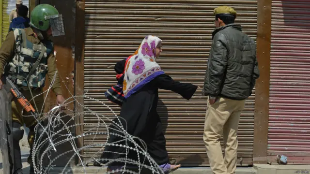 انڈیا کے زیرِ انتظام کشمیر کے دارالحکومت سری نگر میں ایک مسلمان خاتون خار دار تار کو عبور کرنے کی کوشش کر رہی ہے۔ حکام نے سری نگر کے لال چوک اور اس کے گرد و نواح کے علاقوں میں بدھ کو خودمختار کشمیر کے حامی امان اللہ خان کی غائبانہ نمازِ جنازہ ادا کرنے پر پابندی عائد کر دی تھی۔