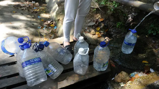 Una persona recogiendo agua