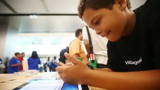 Un niño mira la pantalla de un celular