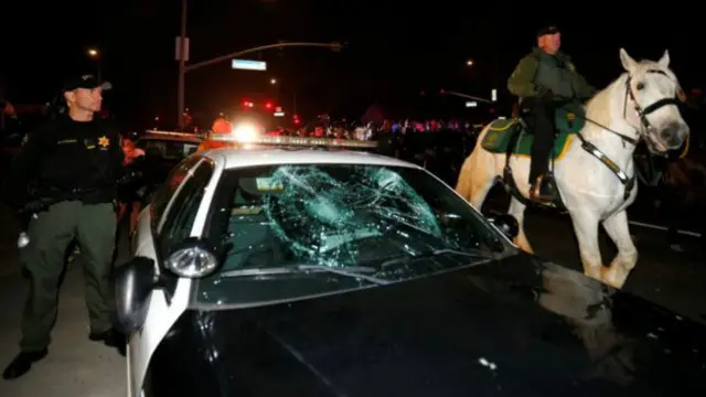 محتجون هشموا زجاج سيارة الشرطة أمام تجمع ترامب الشعبي