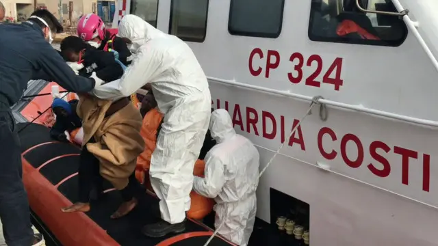 Penjaga Pantai Italia membawa penumpang selamat ke Pulau Lampedusa.