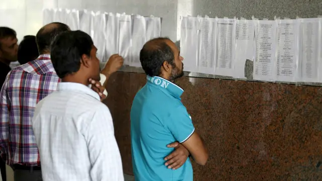 عمال يطالعون كشوفا بأسماء الأشخاص الذين قررت شركة بن لادن الاستغناء عنهم.