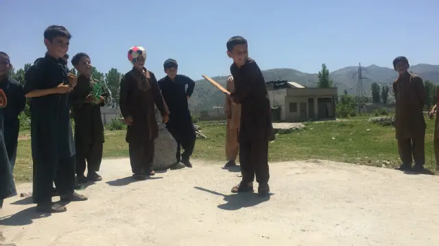 د نړېدلې ودانۍ په ځمکه اوس هلکان کرېکټ کوي.