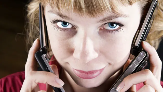 Девушка разговаривает по двум телефонам сразу