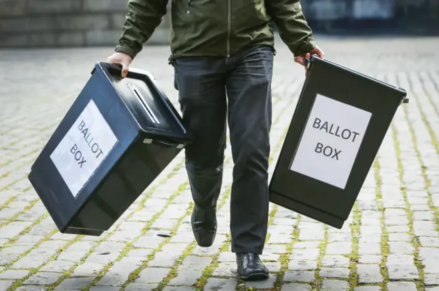 Человек несет урны для голосования в Эдинбурге
