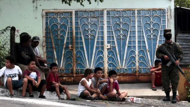 Un policía encapuchado custodia una calle en El Salvador