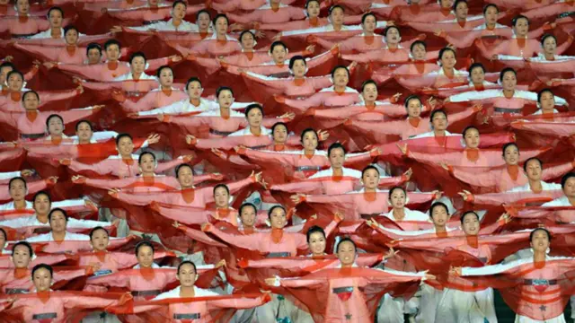 Chương trình được hàng chục ngàn người thưởng thức - mà nhiều người được đơn vị, cơ quan của mình đưa tới từ các vùng nông thôn tới - trong sân vận động có sức chứa lớn nhất thế giới. Điều gây kinh ngạc nhất trong các màn trình diễn này là sự màu mè rực rỡ vô cùng. Hầu hết buổi biểu diễn là cảnh các diễn viên trong trang phục lấp lánh trang kim thực hiện những màn thể dục nhào lộn siêu phẩm.
