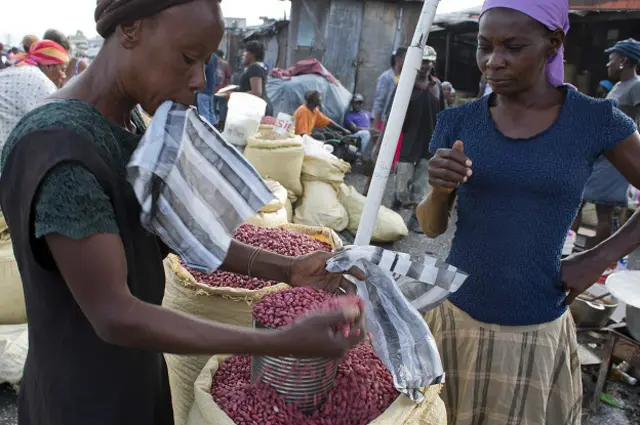 Una vendedora de maní le vende a otra mujer 