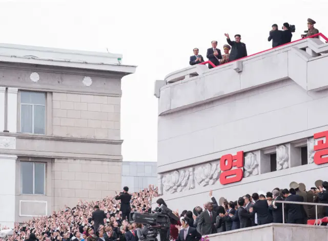 Nhiều người Bắc Hàn ngước lên nhìn về phía ban công nơi có ông Kim Jong-un với gương mặt hưng phấn