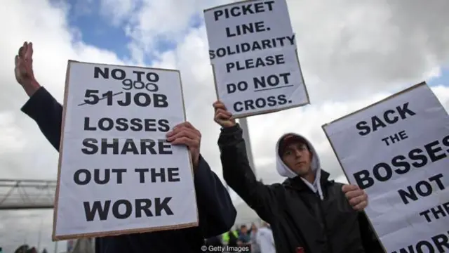 裁员过后，罢工者在英格兰格林斯比的林赛炼油厂外高举标语(图片来源：Getty Images)