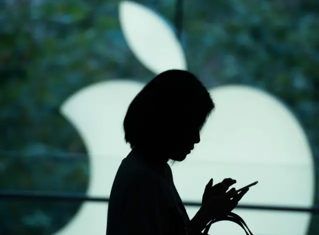 Una persona con un fondo del logo de Appl