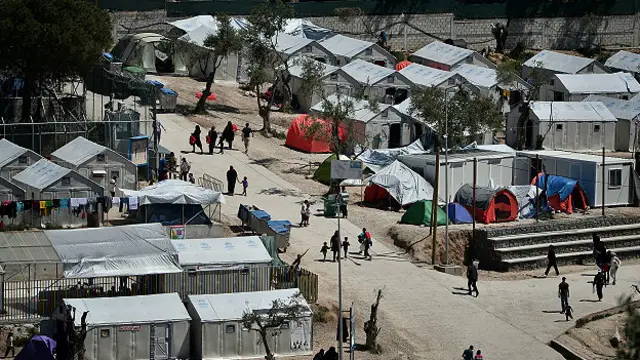 Los solicitantes de asilo esperan en el campo de Moria.