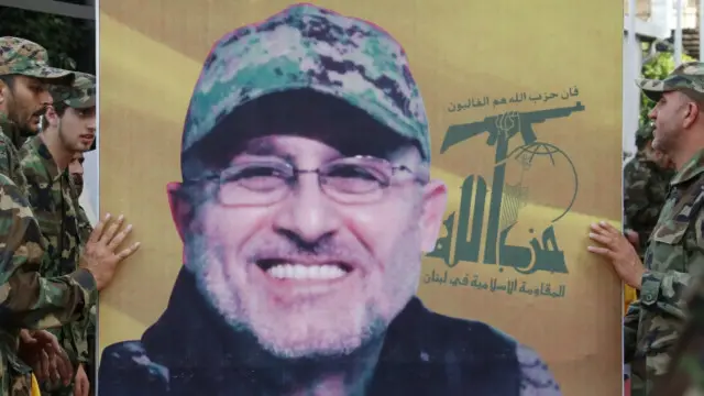 اعضای حزب‌الله در بیروت تصویری از مصطفی بدرالدین را در مراسم تشییع جنازه او در دست گرفته‌اند