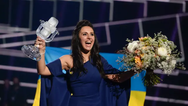 贾马拉在舞台上手举奖杯