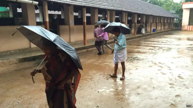 کوچی میں بارش ہو رہی ہے اور لوگ چھتری لگا کر ووٹ ڈالنے جا رہے ہیں