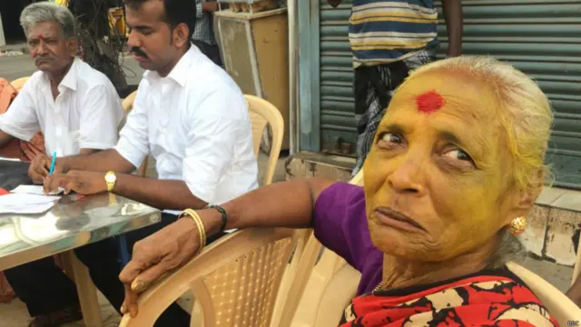 एक बूथ पर इंतज़ार करती एक महिला.