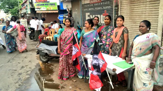 मतदान केंद्र के बाहर एक बूथ पर बैठी महिलाएं.