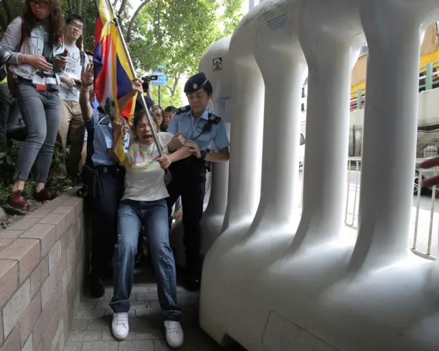 一名手持雪山狮子旗的女示威者试图冲破水马防线被女警制服（18/5/2016）