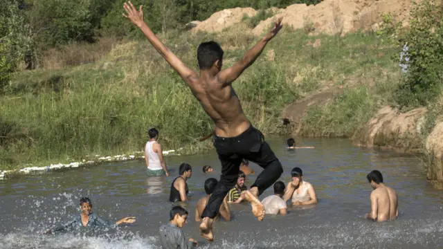 اسلام آباد میں واقع ایک تالاب میں بچے گرمی کی شدت دور کرنے کے لیے نہا رہے ہیں
