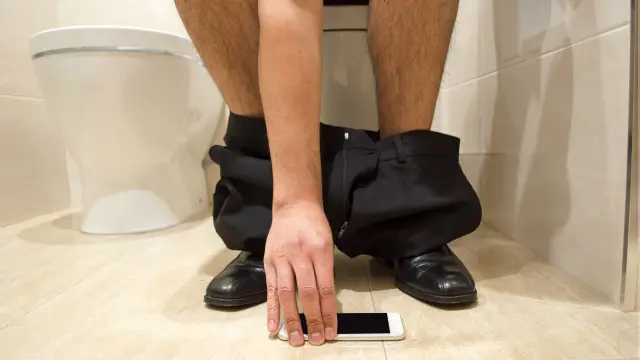 Una persona con el teléfono en el baño