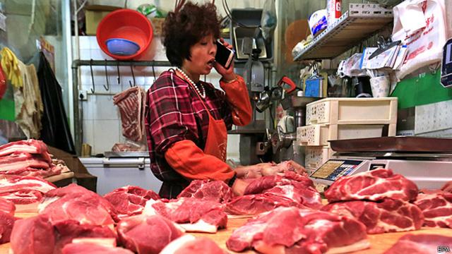 Mujer en un mercado en China vendiendo carne