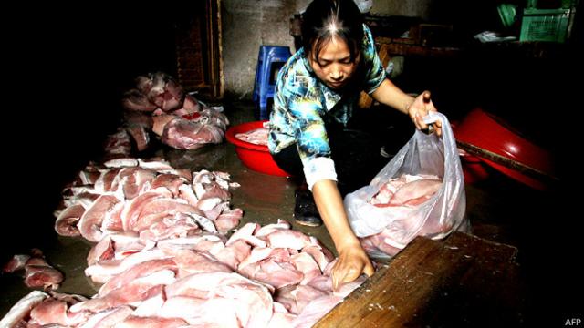 Mujer recogiendo carne en mal estado en Fuzhou, en la provincia de Fujian en 2005