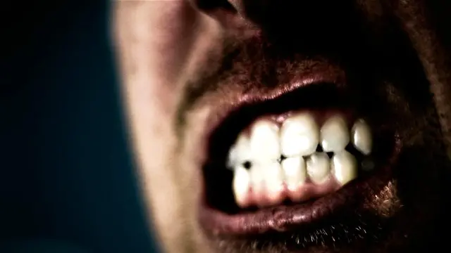 Una persona apretando los dientes en medio de un gran esfuerzo