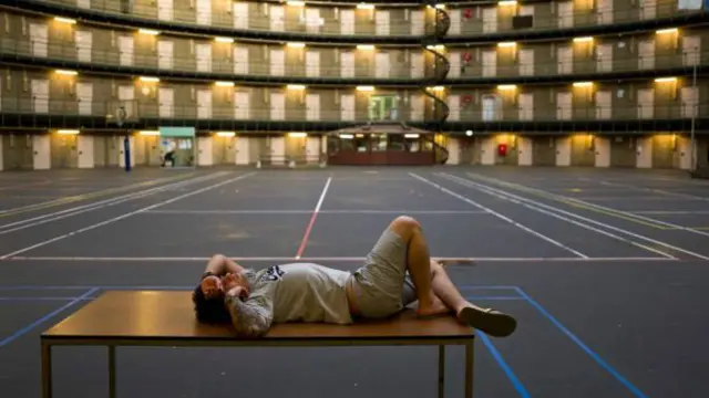 Un refugiado descansa sobre una mesa en la cárcel de De Koepel