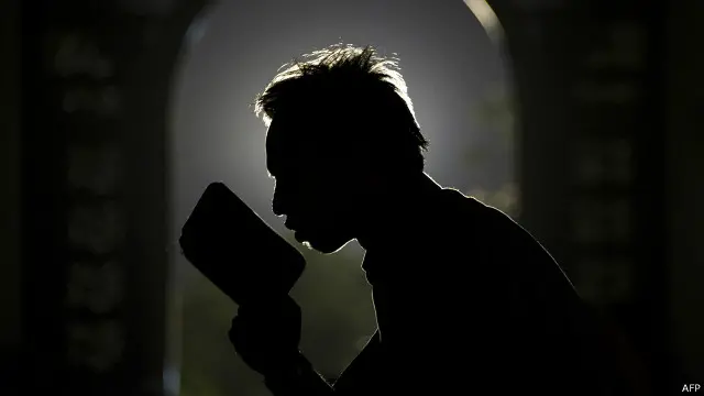 Seorang pemuda Muslim tengah membaca kita suci Al-Quran di sebuah masjid.