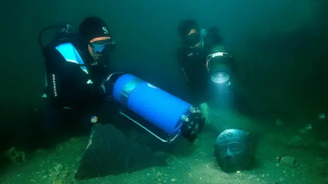 Arqueólogos toman fotos de una escultura en Canopus.