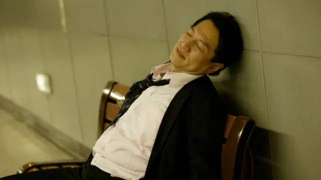 Un ejecutivo dormido en un banco