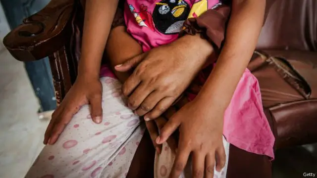 Seorang ibu memangku anaknya. Sanksi yang diatur dalam Perppu kekerasan seksual terhadap anak dianggap sebagai putusan emosional, reaktif dan diragukan efektivitasnya.