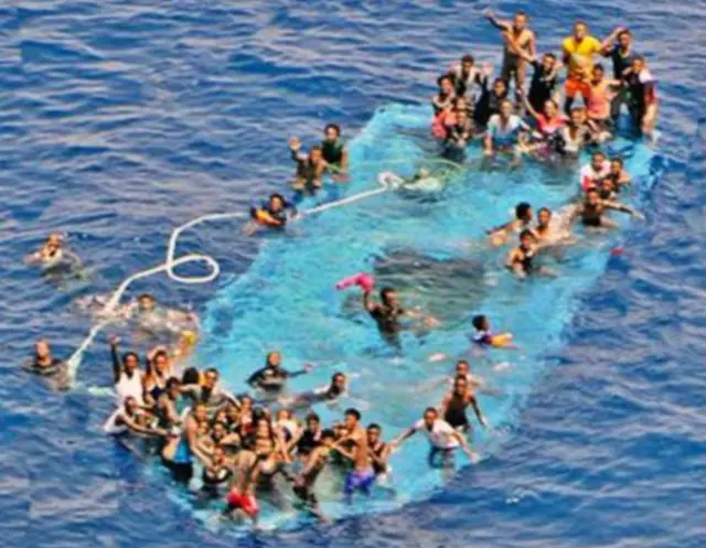 移民在“不适合航行”的橡皮艇上被搜救人员救起。