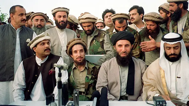 پایگاه ارتش در ۲۰ کیلومتری شرق کابل، ۲۵ مه ۱۹۹۲.حکمتیار و احمدشاه مسعود در میان دو میانجی سعودی (عبدالله نائف؛ راست، اول) و پاکستانی (اعجازالحق، وزیر کار؛ چپ، آخر). جمعیت و حزب اسلامی رقابت دیرینه‌ای دارند