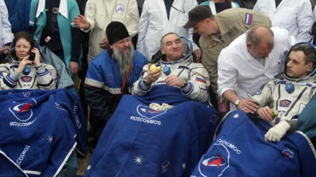 在哈萨克斯坦境内的拜科努尔（Baikonur），人们向宇航员赠与苹果庆祝他们的平安返回地球。(图片来源: Getty Images)