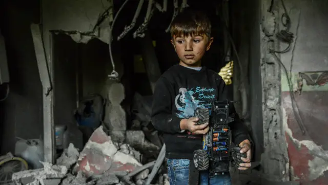 Хлопчик стоїть у руїнах будинку, який постраждав під час сутички урядових військ з курдськими бойовиками на південному сході Туреччини. Юксекова, Туреччина, травень, 2016.