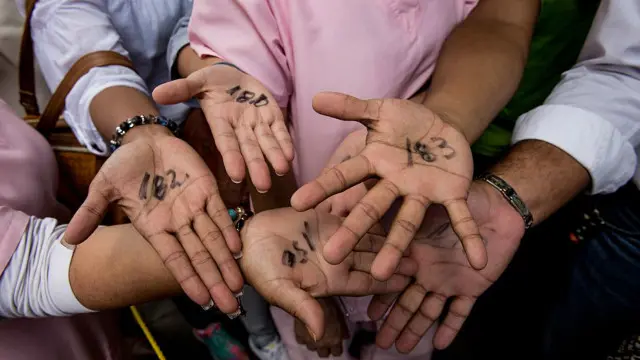 Personas con las manos marcadas