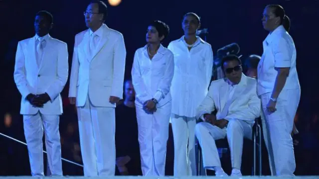 محمد علي (الثاني من على اليمين) يحضر حفل افتتاح أوليمبياد لندن عام 2012، إلى جانب الأمين العام للأمم المتحدة بان كي مون (الثاني من على اليسار)، وعداء المسافات الطويلة هايلي جبريسيلاسي (على أقصى اليسار).