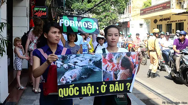 Người tuần hành mang theo biểu ngữ trong đó đặt dấu hỏi về vai trò của Quốc hội trước vụ cá chết hàng loạt và bất thường.
