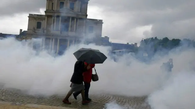 Qadınlar Parisdə gözyaşardıcı qazın içindən keçərək gedirlər