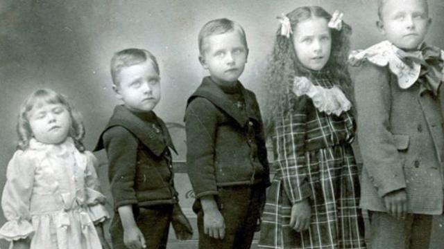 Fotografía de varios niños con una hermanita muerta.