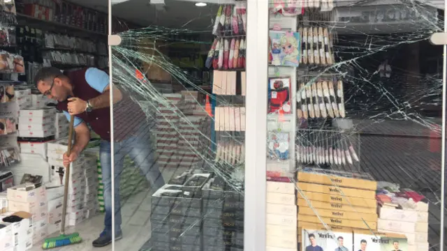 Vezneciler esnafı saldırı sonrasında hasar gören dükkânlarını ve çevredeki cam kırıklarını temizledi. 