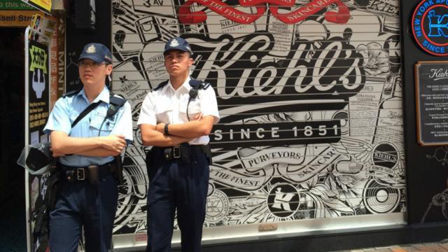 香港銅鑼灣街頭警員在關門的契爾氏分店外駐足（BBC圖片8/6/2016）
