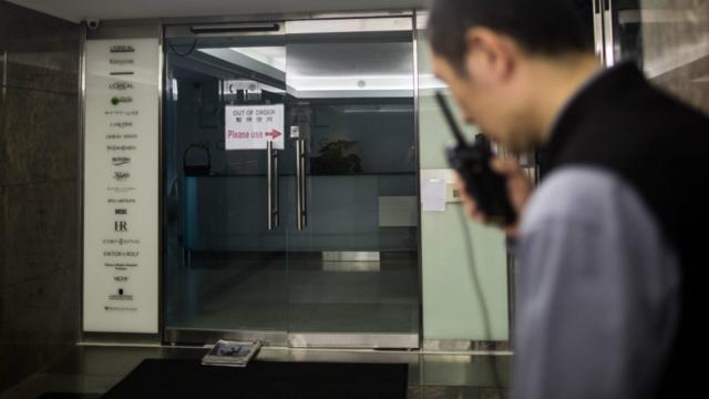 香港銅鑼灣歐萊雅辦事處外一名保安員拿著無線電對講機通話（8/6/2016）