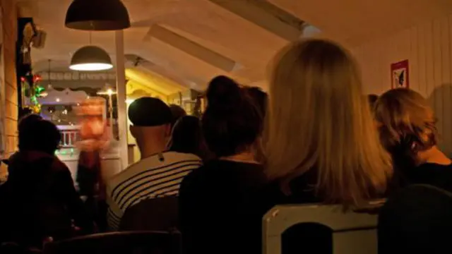 人们聚集在飞蛾与蝴蝶俱乐部聆听讲故事人生动的讲述