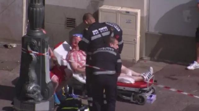 Dua anggota medis Prancis tengah menolong suporter yang terluka akibta bentrokan antar suporter fanatik.