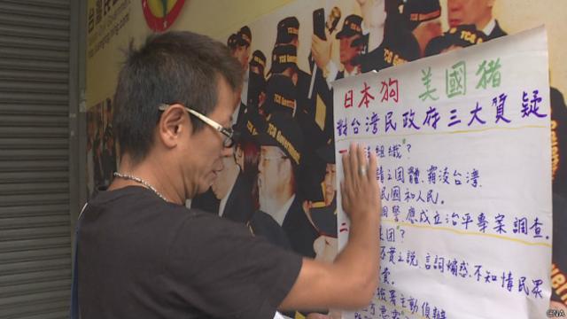民眾到台灣民政府辦事處貼海報抗議